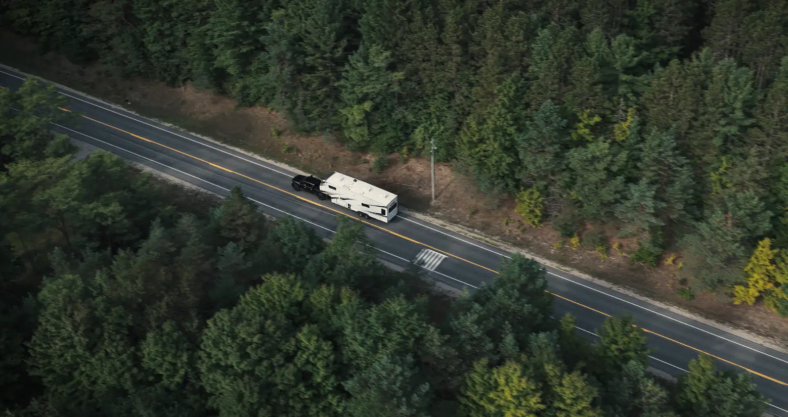 A recreational vehicle travelling along a forest road